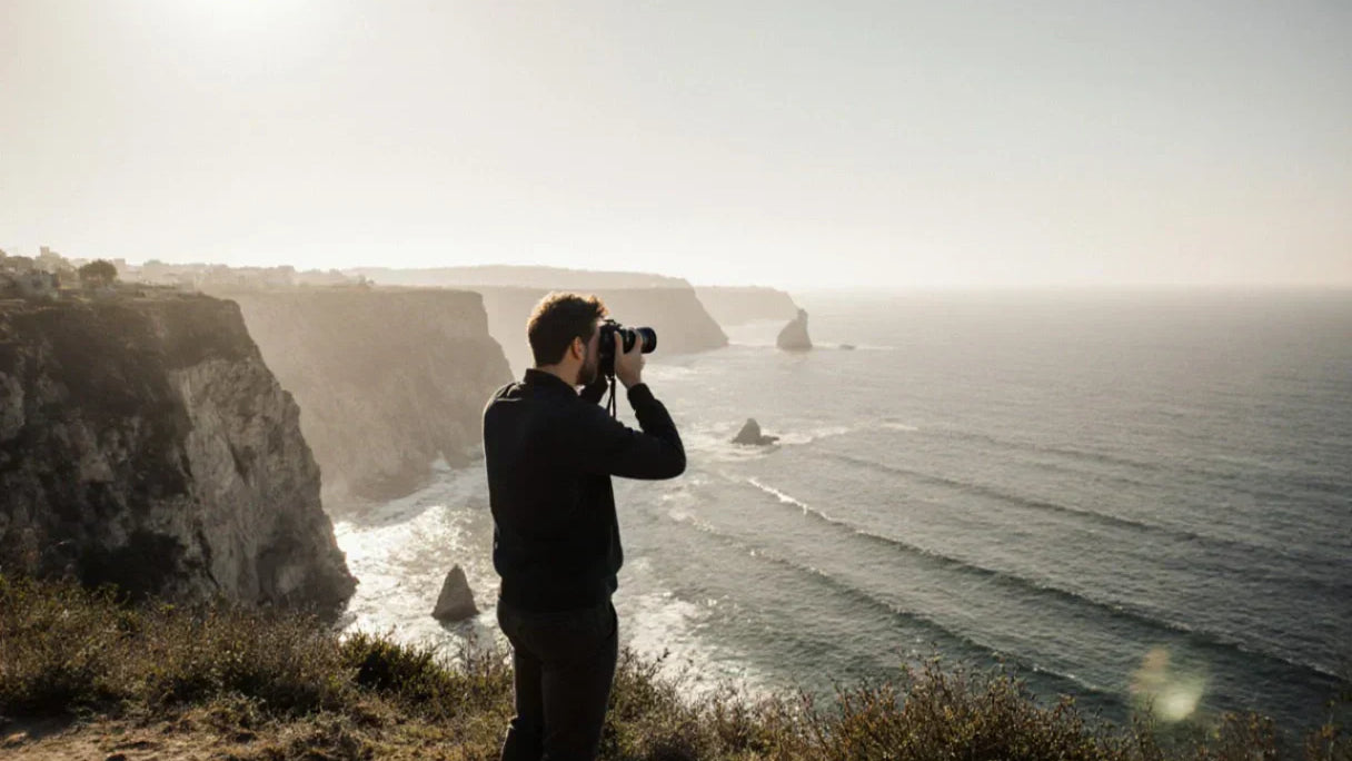 photographe-en-bord-de-falaise-capturant-le-paysage-maritime-au-coucher-du-soleil
